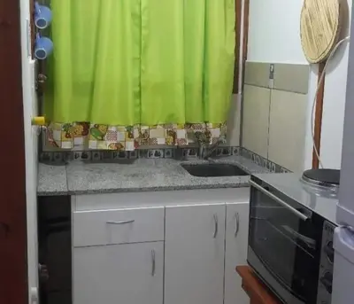 a kitchen with a sink and a green curtain at Cabaña 2 in Cordoba