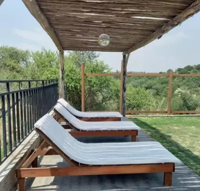 two benches on a deck with a wooden roof at Cabaña 2 in Cordoba