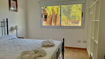 a bedroom with a bed and a large window at Tata Inti Complejo Serrano in Merlo