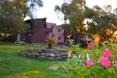 a garden in front of a house with flowers at Tata Inti Complejo Serrano in Merlo