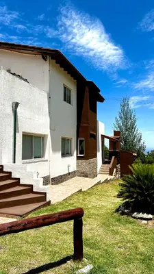 a house with stairs and a bench in front of it at Tata Inti Complejo Serrano in Merlo
