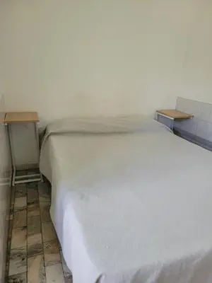 a white bed in a room with two tables at Hotel CAMACHO in Cordoba