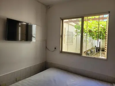 a small room with a bed and a window at Hotel CAMACHO in Cordoba