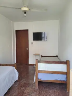 a room with two beds and a flat screen tv at Hotel CAMACHO in Cordoba
