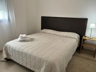 a bedroom with a large bed with a black headboard at Departamento 6 piso con piscina, de 1 dormitorio in Río Cuarto