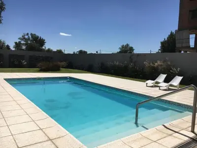 a swimming pool with two lounge chairs next to it at Departamento 6 piso con piscina, de 1 dormitorio in Río Cuarto