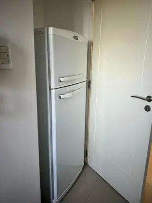 a white refrigerator in a kitchen next to a wall at Departamento 6 piso con piscina, de 1 dormitorio in Río Cuarto