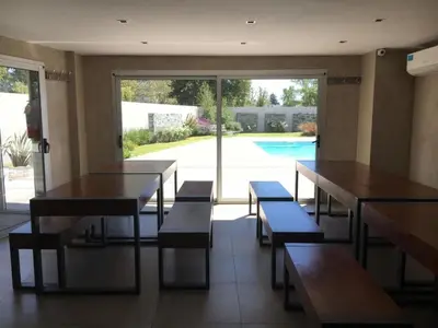 a restaurant with tables and benches and a pool at Departamento 6 piso con piscina, de 1 dormitorio in Río Cuarto