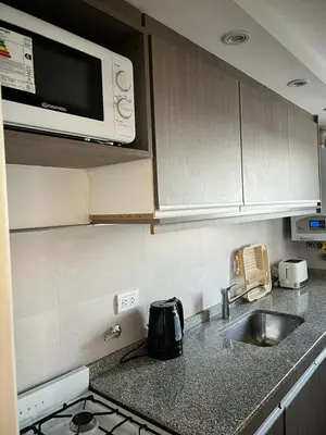a kitchen with a sink and a microwave at Departamento 6 piso con piscina, de 1 dormitorio in Río Cuarto