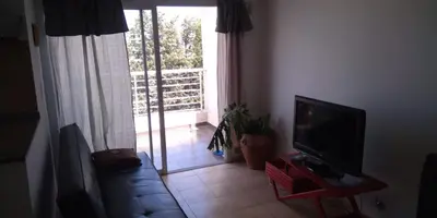 a living room with a television and a sliding glass door at Cálido departamento en CBA in Cordoba
