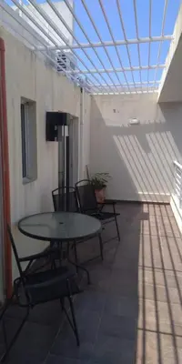 a table and chairs in a room with a ceiling at Cálido departamento en CBA in Cordoba