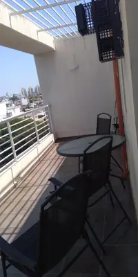 a room with a table and chairs on a balcony at Cálido departamento en CBA in Cordoba