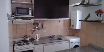 a small kitchen with a sink and a microwave at Cálido departamento en CBA in Cordoba