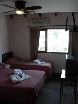 a hotel room with two beds and a window at Hotel Verde Sol in Villa Carlos Paz