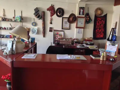 a cluttered room with a desk with hats on the wall at Hotel Verde Sol in Villa Carlos Paz