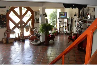 a living room with a tile floor and a staircase at Hotel Verde Sol in Villa Carlos Paz