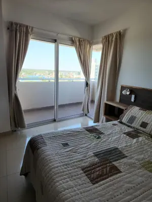 a bedroom with a bed and a large window at TORRE MAFALDA 15 Departamento nuevo con Pileta in Río Cuarto