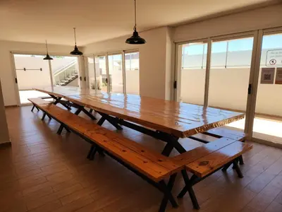 a large wooden table in a room with windows at TORRE MAFALDA 15 Departamento nuevo con Pileta in Río Cuarto