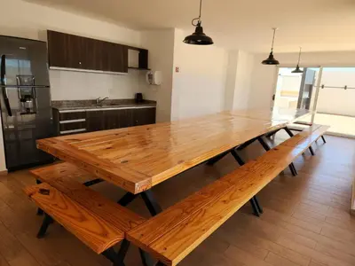 a wooden table in a kitchen with a wooden floor at TORRE MAFALDA 15 Departamento nuevo con Pileta in Río Cuarto