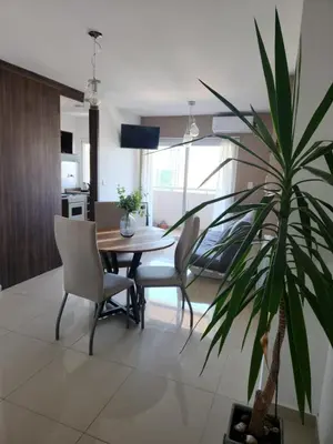 a dining room with a table and chairs and a palm tree at TORRE MAFALDA 15 Departamento nuevo con Pileta in Río Cuarto