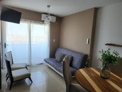 a living room with a blue couch and a table at TORRE MAFALDA 15 Departamento nuevo con Pileta in Río Cuarto