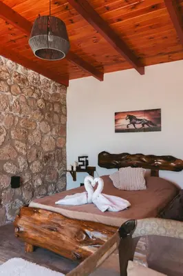 a bedroom with a bed in a stone wall at EL PALMAR in Villa Carlos Paz