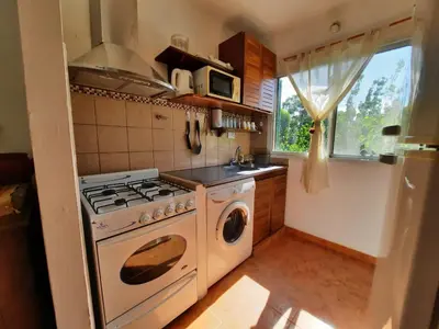 a kitchen with a stove and a washing machine at Nuestro Balcón a las Sierras in Merlo