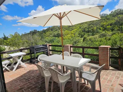 a white table and chairs with an umbrella at Nuestro Balcón a las Sierras in Merlo