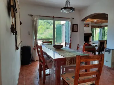 a kitchen with a table with chairs and a large window at Nuestro Balcón a las Sierras in Merlo