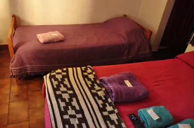 a room with two beds with towels on a couch at Hotel La Marina in Villa Carlos Paz