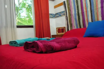 a woman laying on top of a red bed at Hotel La Marina in Villa Carlos Paz