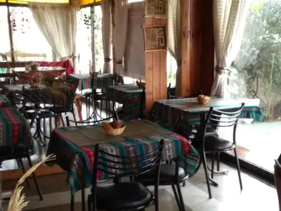a dining room with tables and chairs and windows at Hotel La Marina in Villa Carlos Paz