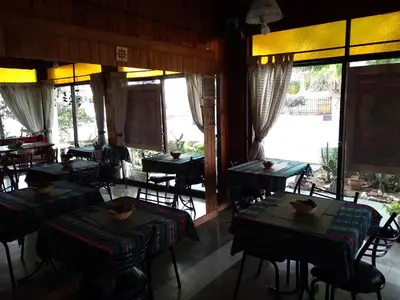 a restaurant with tables and chairs and large windows at Hotel La Marina in Villa Carlos Paz
