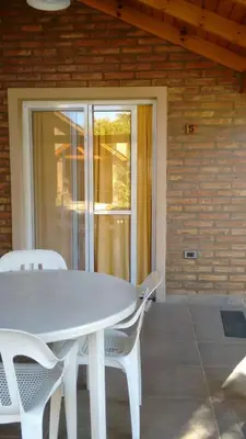 a white table and chairs in front of a house at Cabañas Amanecer en el Lago in Villa del Dique