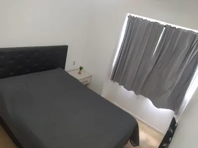 a bedroom with a black bed and a window at Dto Costanera Antigua Cerveceria 3 dorm 2 cocheras 4 cuadras del centro in Cordoba