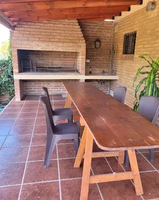 a wooden table and chairs on a patio at Cabañas Brick House in Embalse