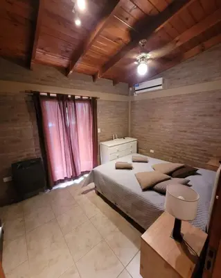 a bedroom with a large bed in a room with wooden ceilings at Cabañas Brick House in Embalse