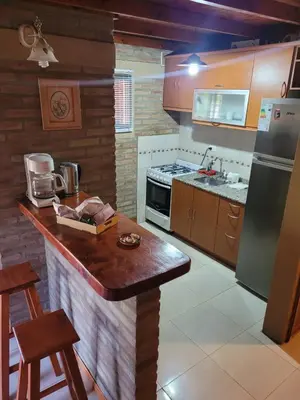 a kitchen with a counter and a refrigerator at Cabañas Brick House in Embalse