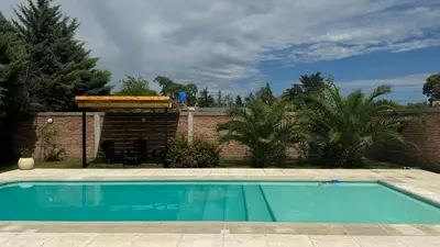 a swimming pool in a yard next to a brick wall at Julias House in Almafuerte