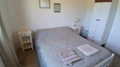 a small bedroom with a bed with two towels on it at Casa de Montaña in Cortaderas