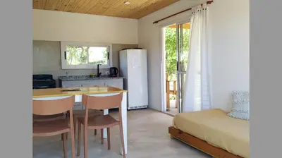 a kitchen with a table and a refrigerator and a bed at Casa de Montaña in Cortaderas