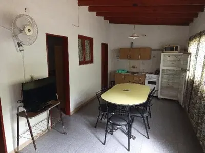 a kitchen with a table and chairs in a room at Los Nidos Dormis Habitaciones con baño privado y DEPARTAMENTOS in Villa Cura Brochero