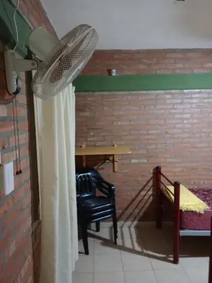 a room with a table and a fan and a chair at Los Nidos Dormis Habitaciones con baño privado y DEPARTAMENTOS in Villa Cura Brochero