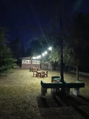 a group of picnic tables in a park at night at Los Nidos Dormis Habitaciones con baño privado y DEPARTAMENTOS in Villa Cura Brochero