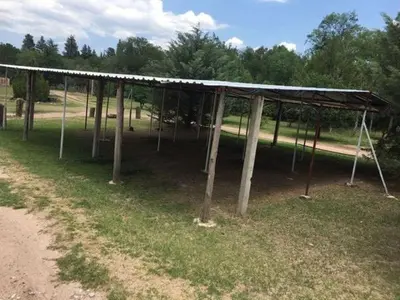 a pavilion in a park with trees in the background at Los Nidos Dormis Habitaciones con baño privado y DEPARTAMENTOS in Villa Cura Brochero