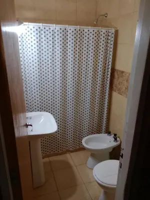 a bathroom with a sink and a toilet and a shower at Los Nidos Dormis Habitaciones con baño privado y DEPARTAMENTOS in Villa Cura Brochero