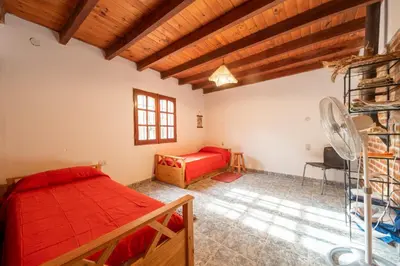 a bedroom with a bed and a desk in a room at CASA EN SANTA ROSA DE CALAMUCHITA in Santa Rosa de Calamuchita