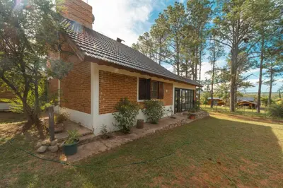 a small house with a garden in front of it at CASA EN SANTA ROSA DE CALAMUCHITA in Santa Rosa de Calamuchita