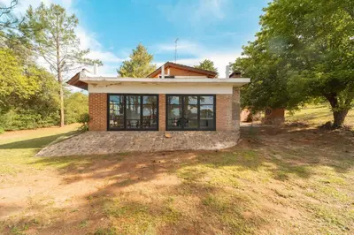 a small brick house with windows on a yard at CASA EN SANTA ROSA DE CALAMUCHITA in Santa Rosa de Calamuchita