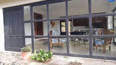 a large window of a house with chairs and a table at CASA EN SANTA ROSA DE CALAMUCHITA in Santa Rosa de Calamuchita